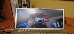 A man taking a photo of himself on a computer screen through cam