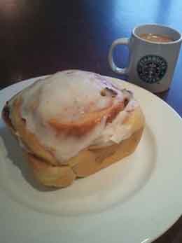Large Cinnamon Roll Next to Small Coffee Showing Desing Principle of Perspective