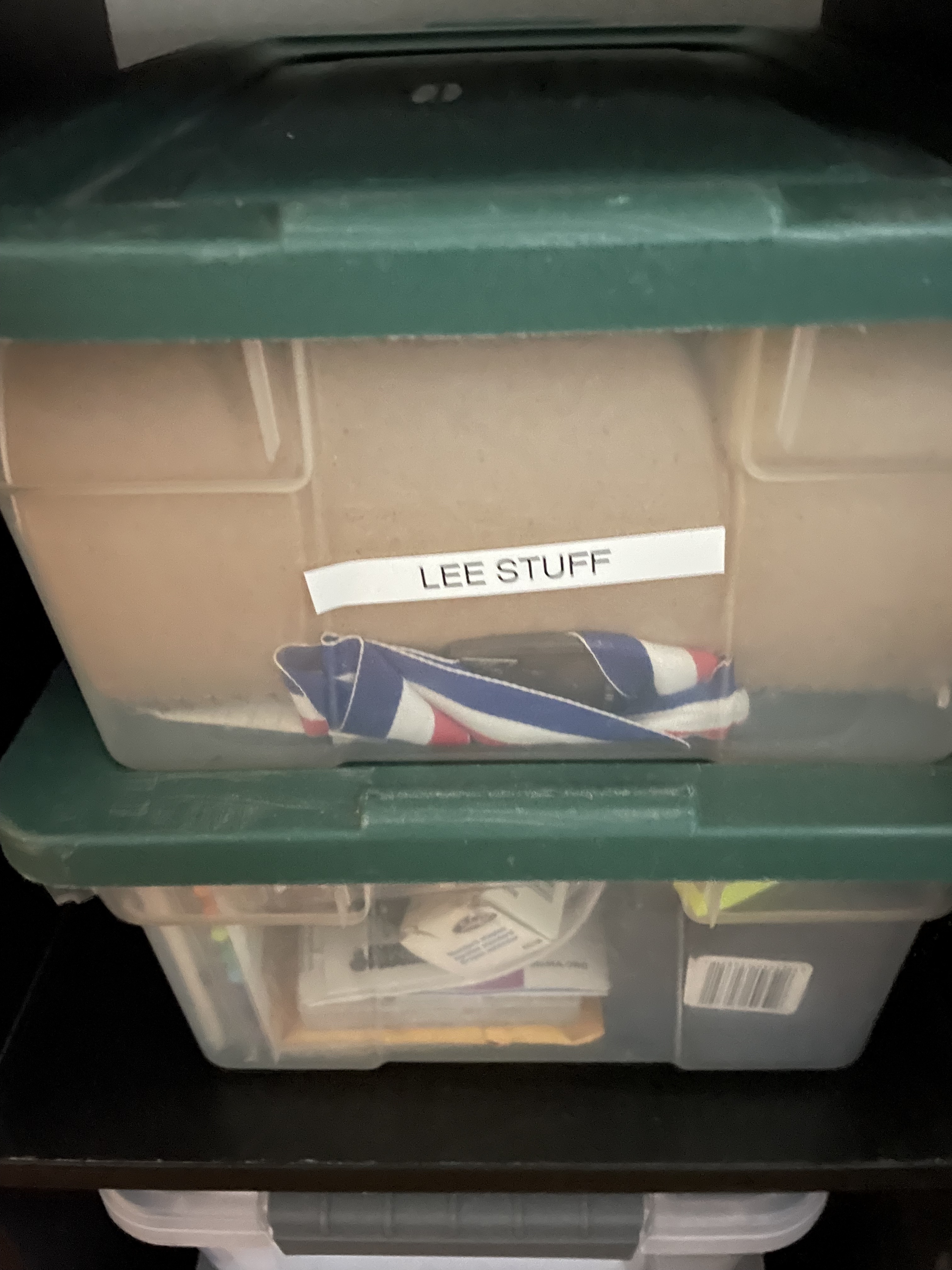Clear bins stacked ontop of one another labeled Lee Stuff