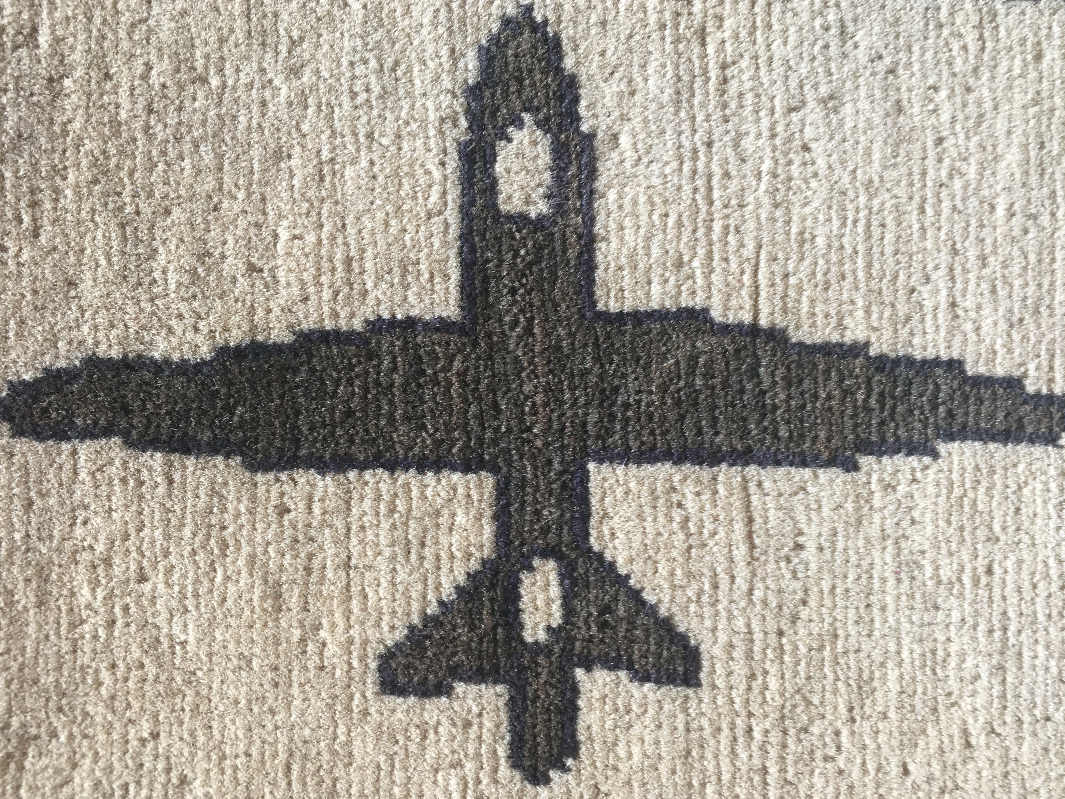 A detail of a bomber plane woven into a war rug