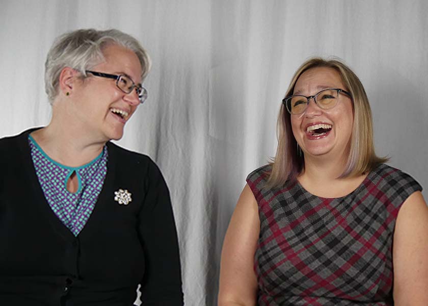 two white women in glasses laughing and looking jovial