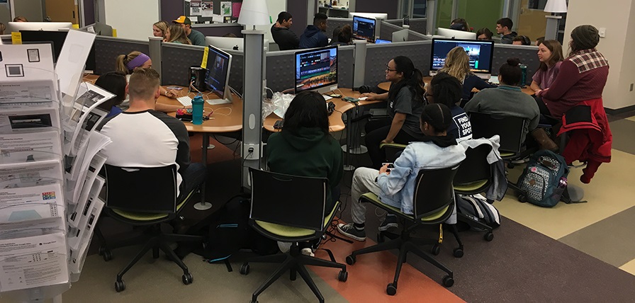 Wide shot of the UTC Library Studio, group of students at computers