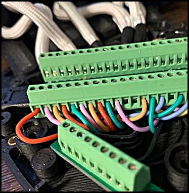 Inside cabling and connectors of a gaming keypad. Colors of the cabling range from green to red.