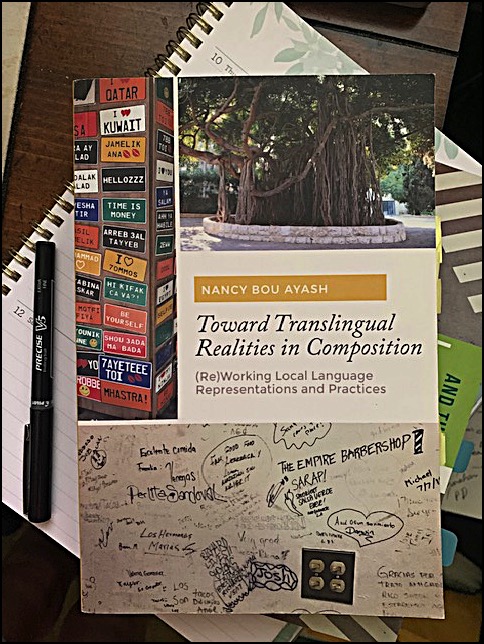 Cover of Bou Ayash's book with the title, a banyan tree image above it, an image of license plates to the left, and an image of writing on a wall below.