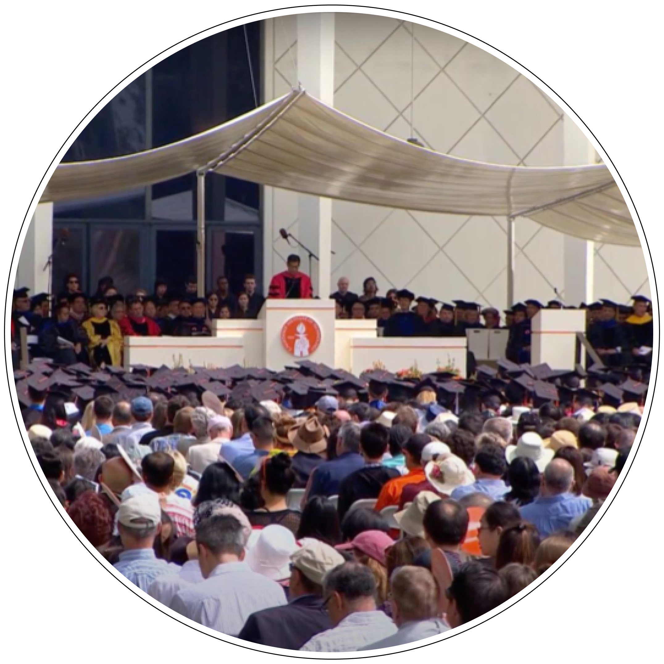 The same commencement speech delivered by Atul Gawande as the header image, but depicting it from a new angle and with friends and family of the graduates seated in the foreground.