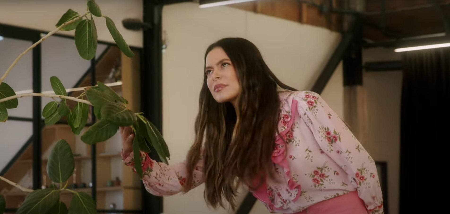 Miranda Cosgrove smells a houseplant.