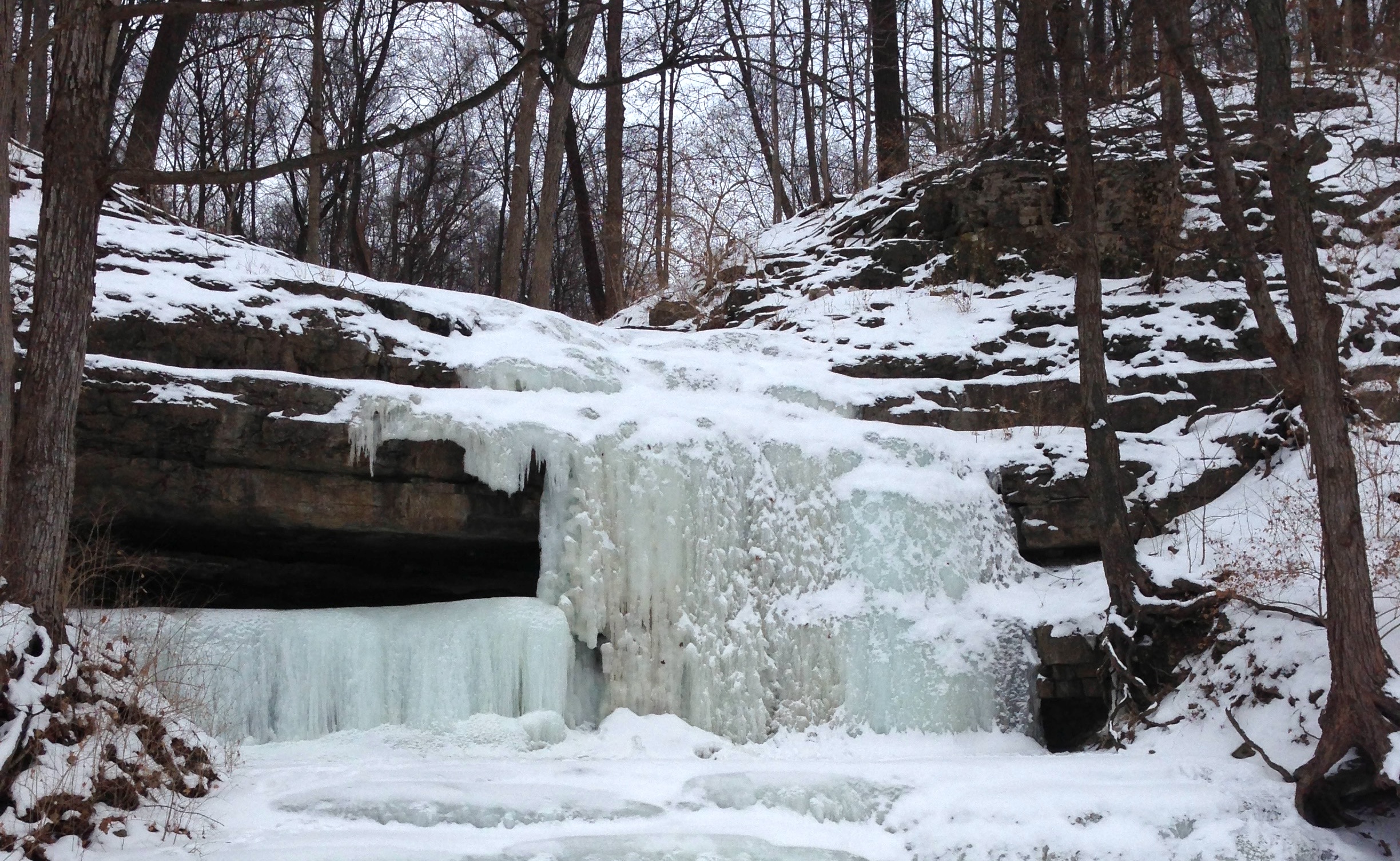 A small frozen waterfall amid rock outcroppings.