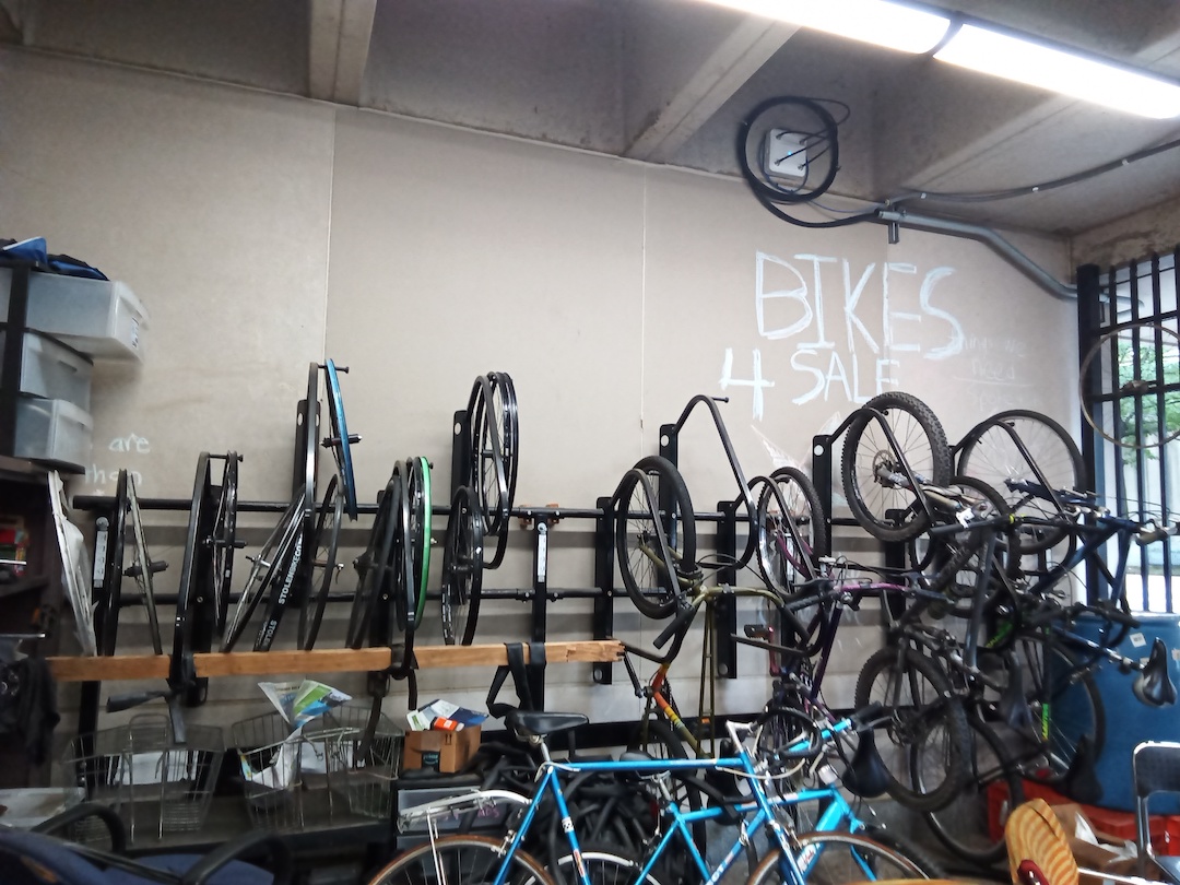 Row of bikes hanging from a concrete wall.