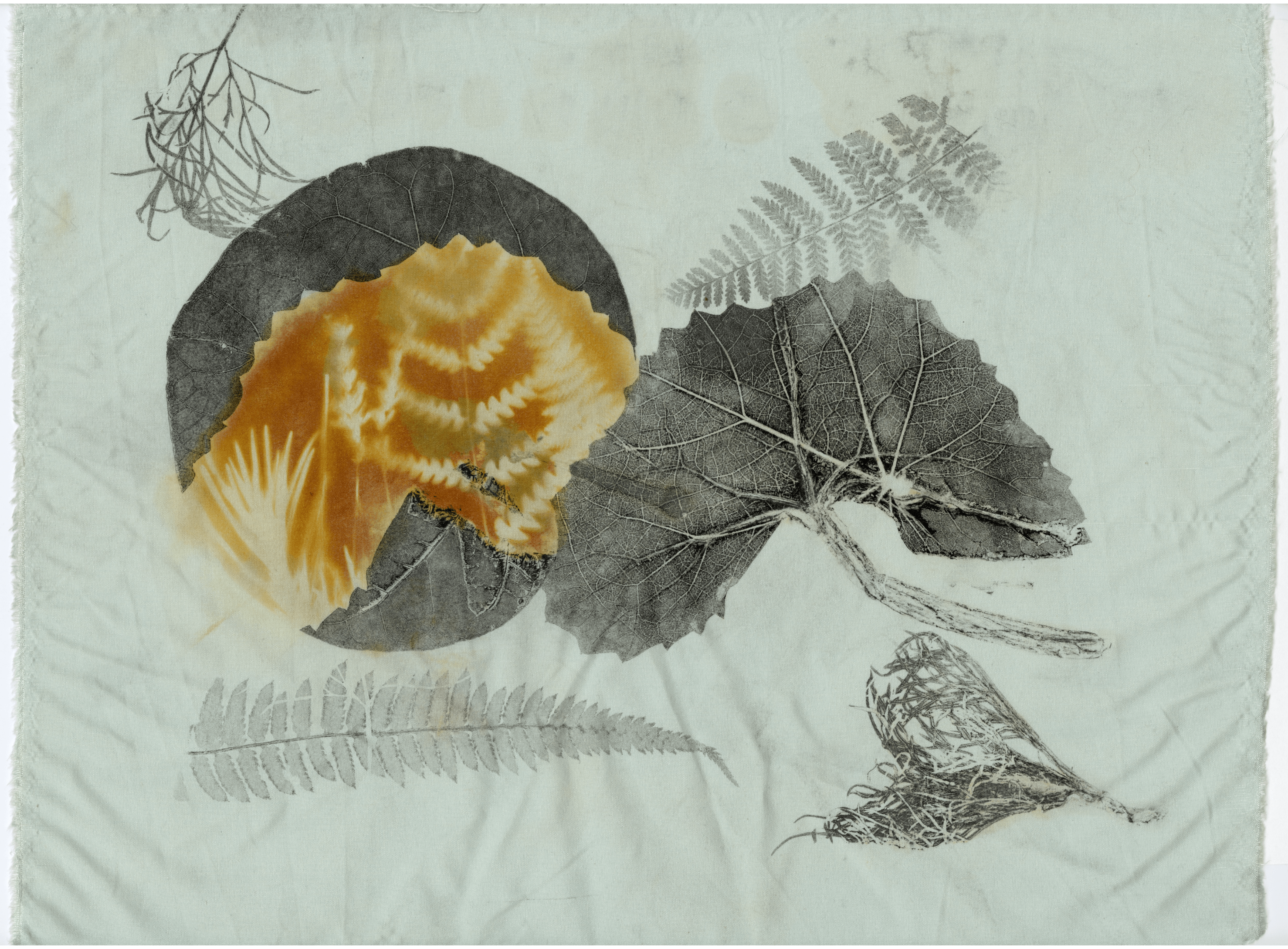A print on fabric featuring a large leaf with a bright orange pattern, surrounded by ferns and other leaves.