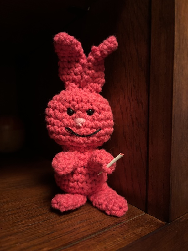 Evil Bunny holds a cigarette in his left hand. He has a mischievious experssion again.