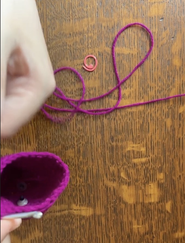 Screenshot from a crochet video tutorial in which the project is not fully in the frame.