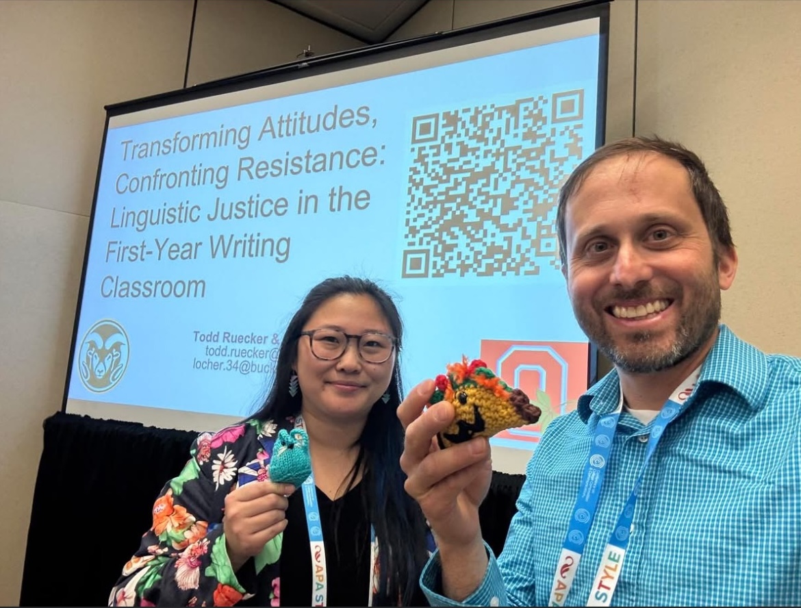 Hannah Locher and Todd Ruecker pose with their conference creatures in front of a screen showing their TYCA 2025 presentation.