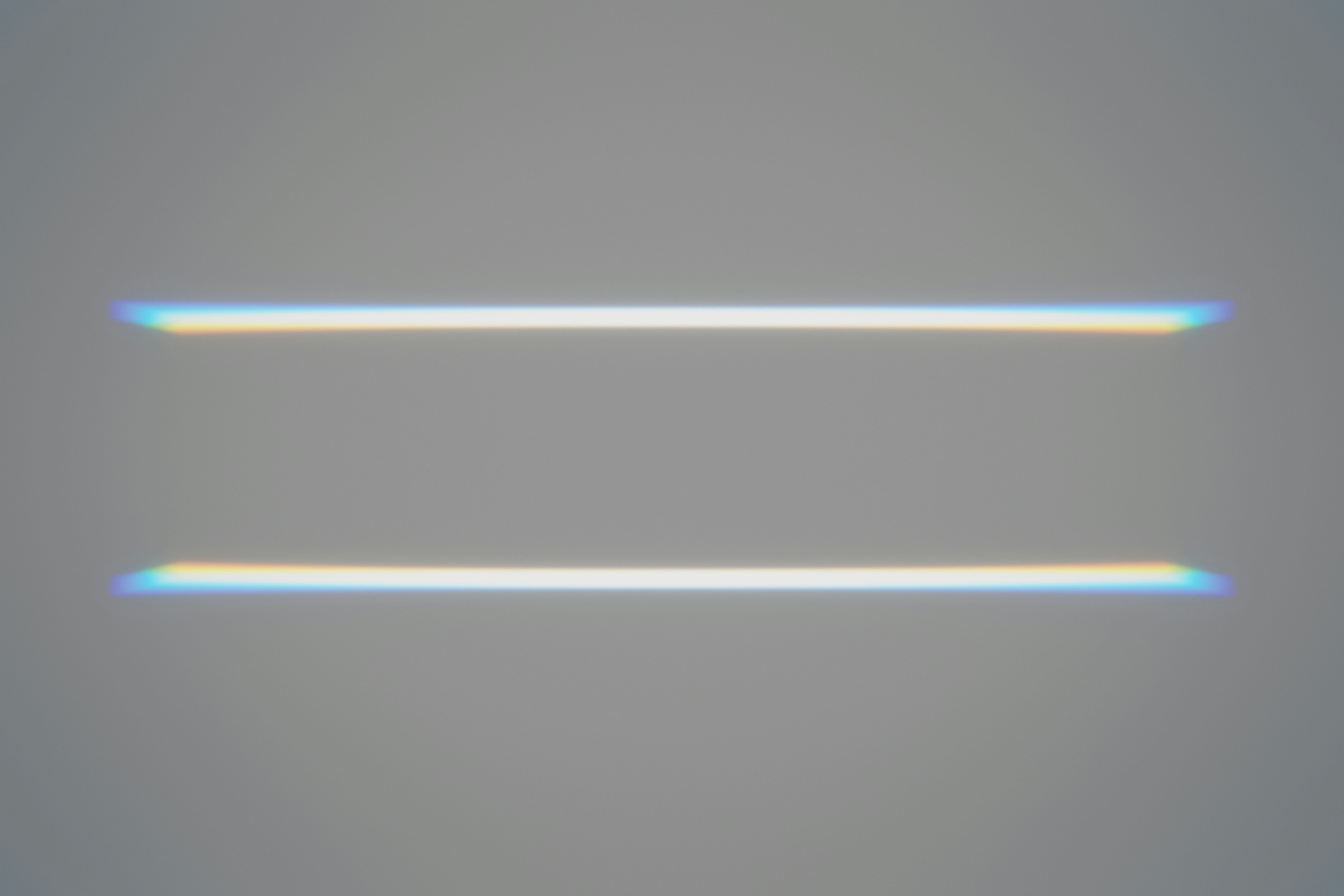 Two parallel slits of horizontal light against a grey background.